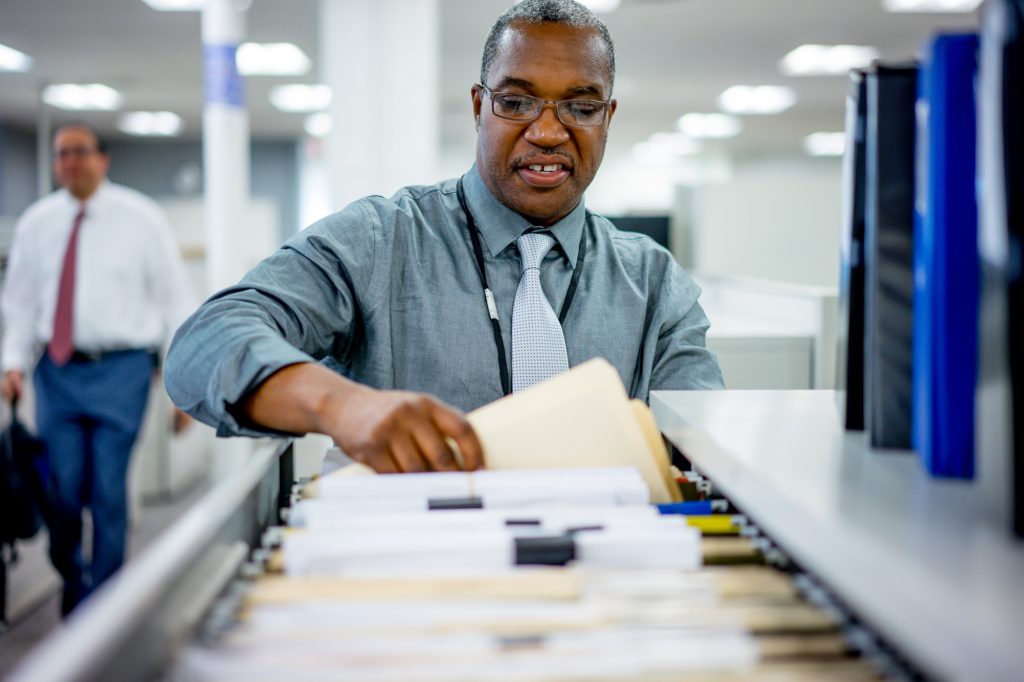 Man looking through files in drawer