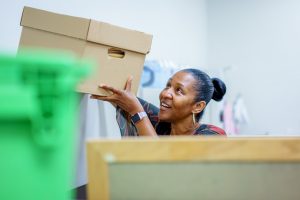 Employee lifting a box onto a shelf