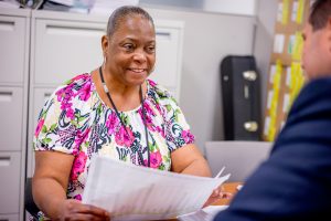 Employee sitting at table holding a paper