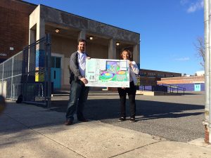 Principal Jenkins and a member of the Friend of Adaire Program pose with plans for the new school yard.