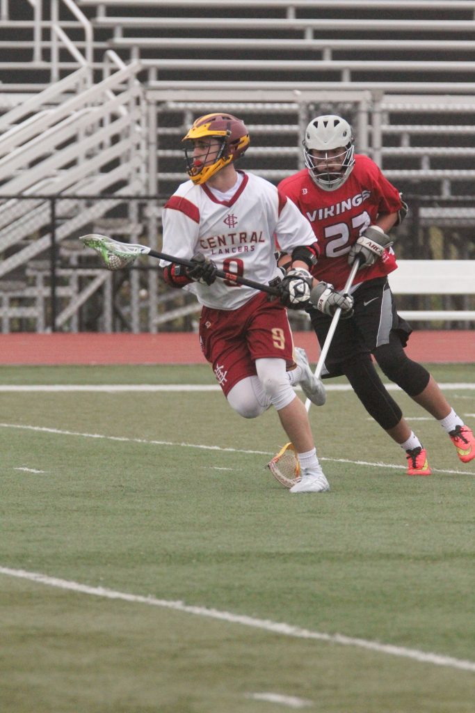 Lacrosse player cradling ball while running forward 