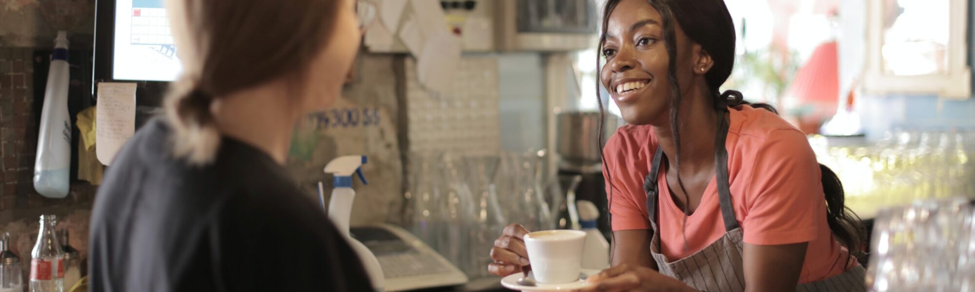 a cafe worker speaking with a customer