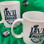 White ceramic mugs that have the print "LVII EAGLES" and the Eagles football team logo