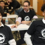 Two Northeast Highschool students smiling, wearing Campaign for Working Families volunteer shirts.
