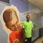 Mr. McKnight in front of his favorite mural at William Dick School.