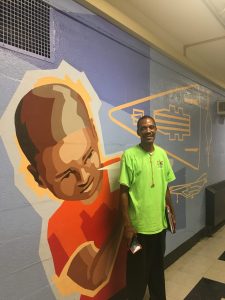 Mr. McKnight in front of his favorite mural at William Dick School.