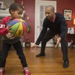 Adult and Child Play Basketball in a living room