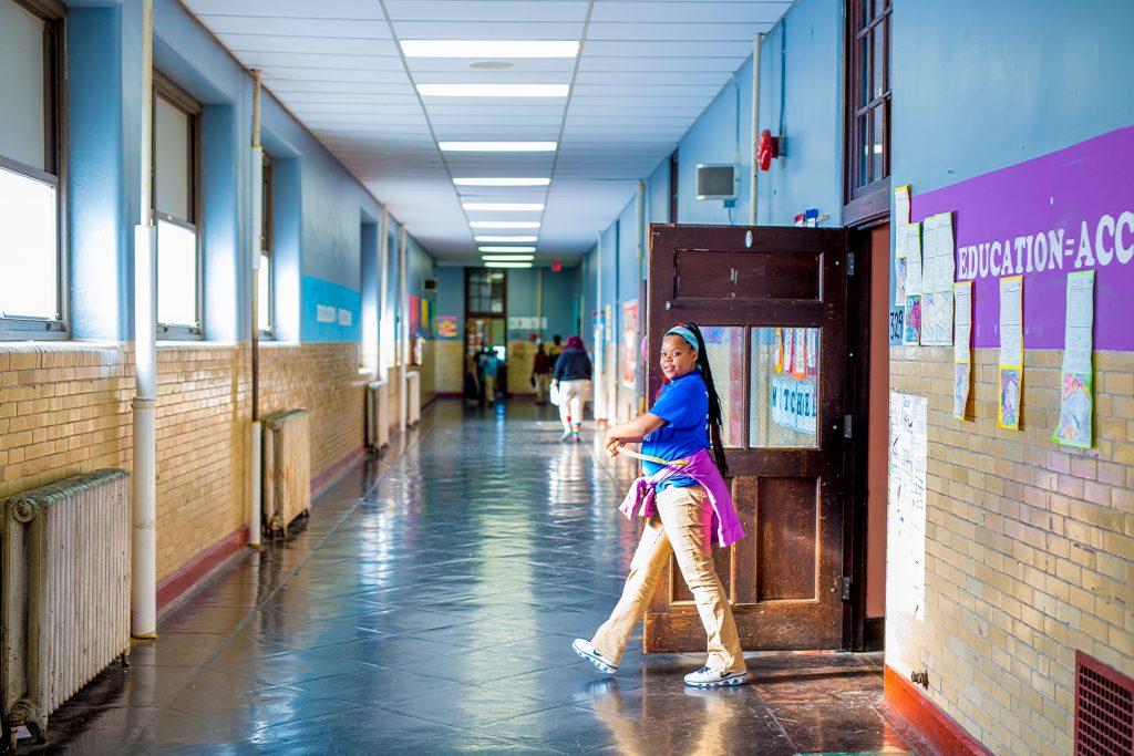 Young girl walking school hallways