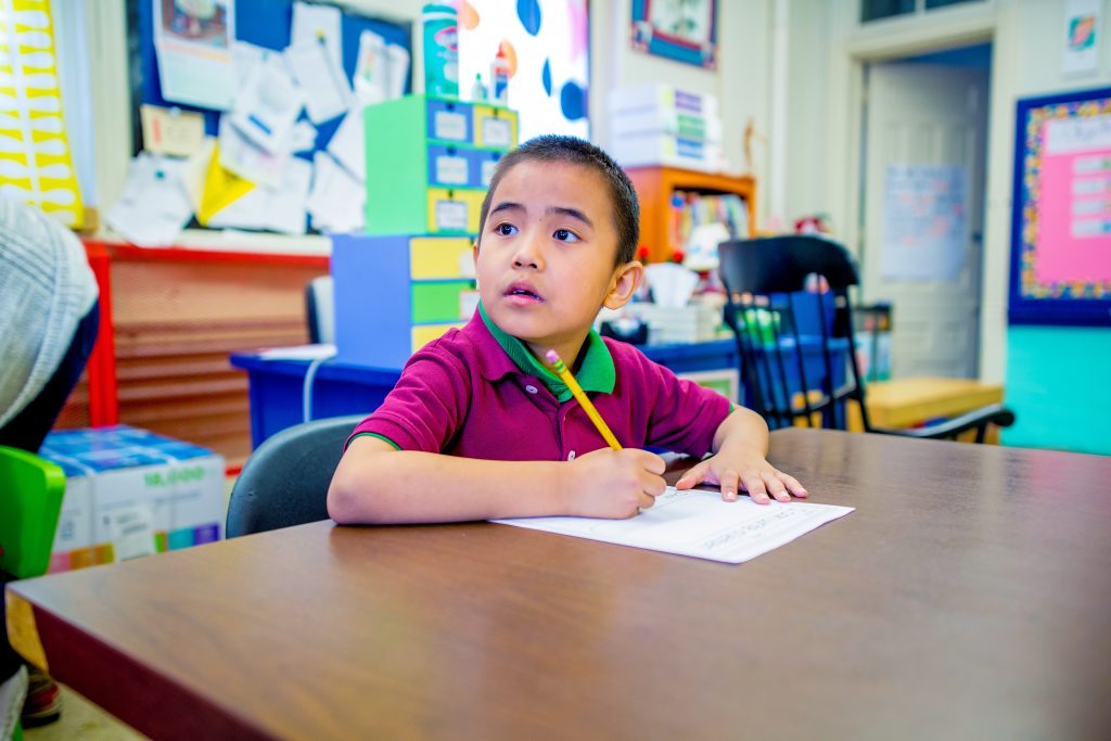 Young boy writing at a desk