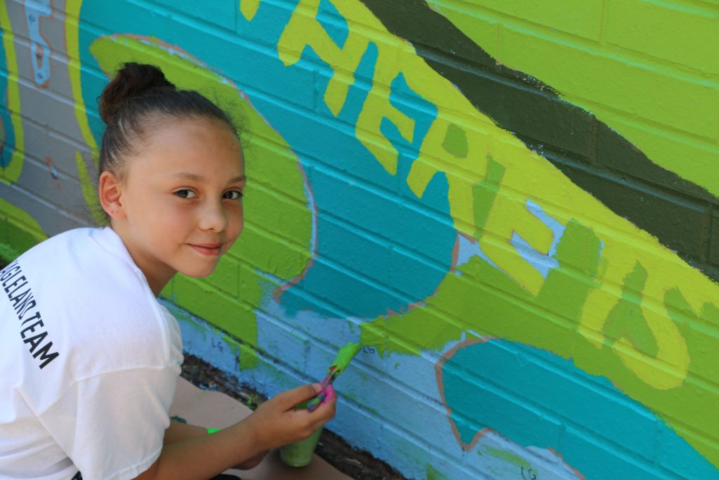 Young child painting a mural