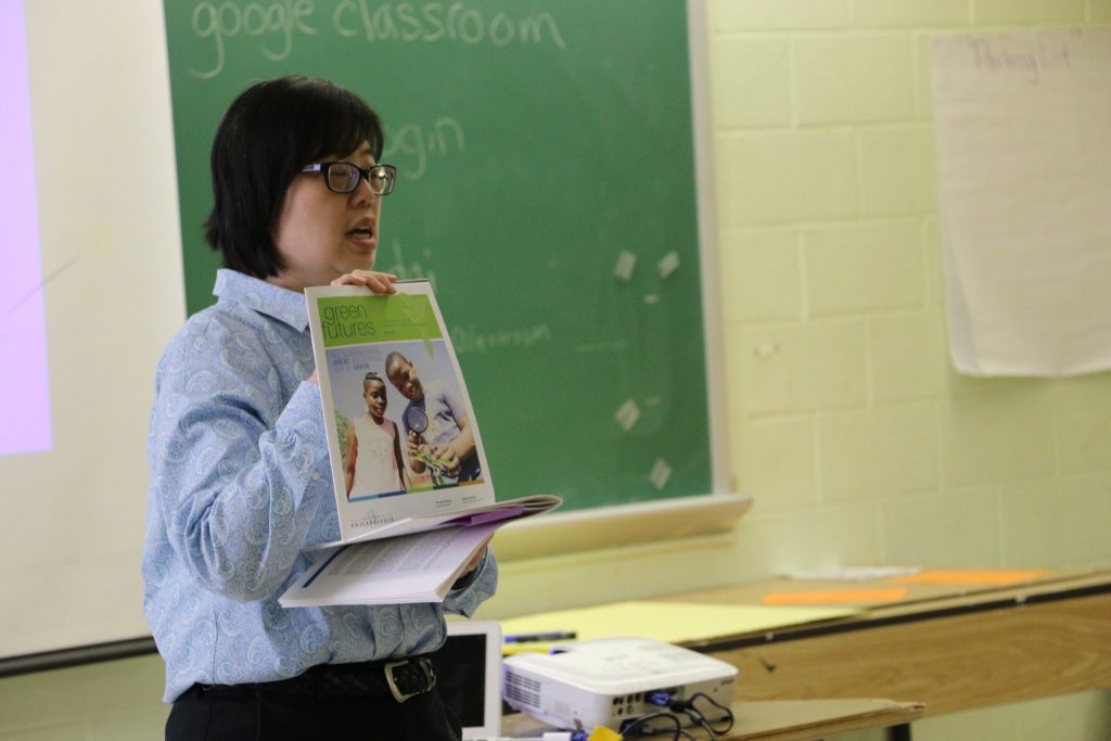 Grant writer holding book in classroom.