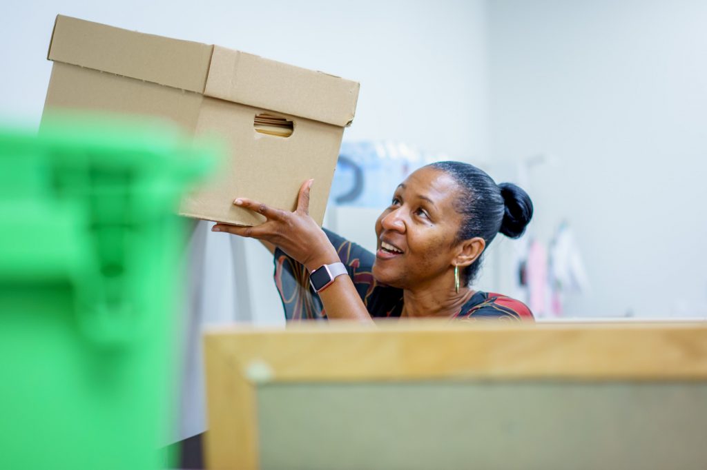 woman lifting a file box