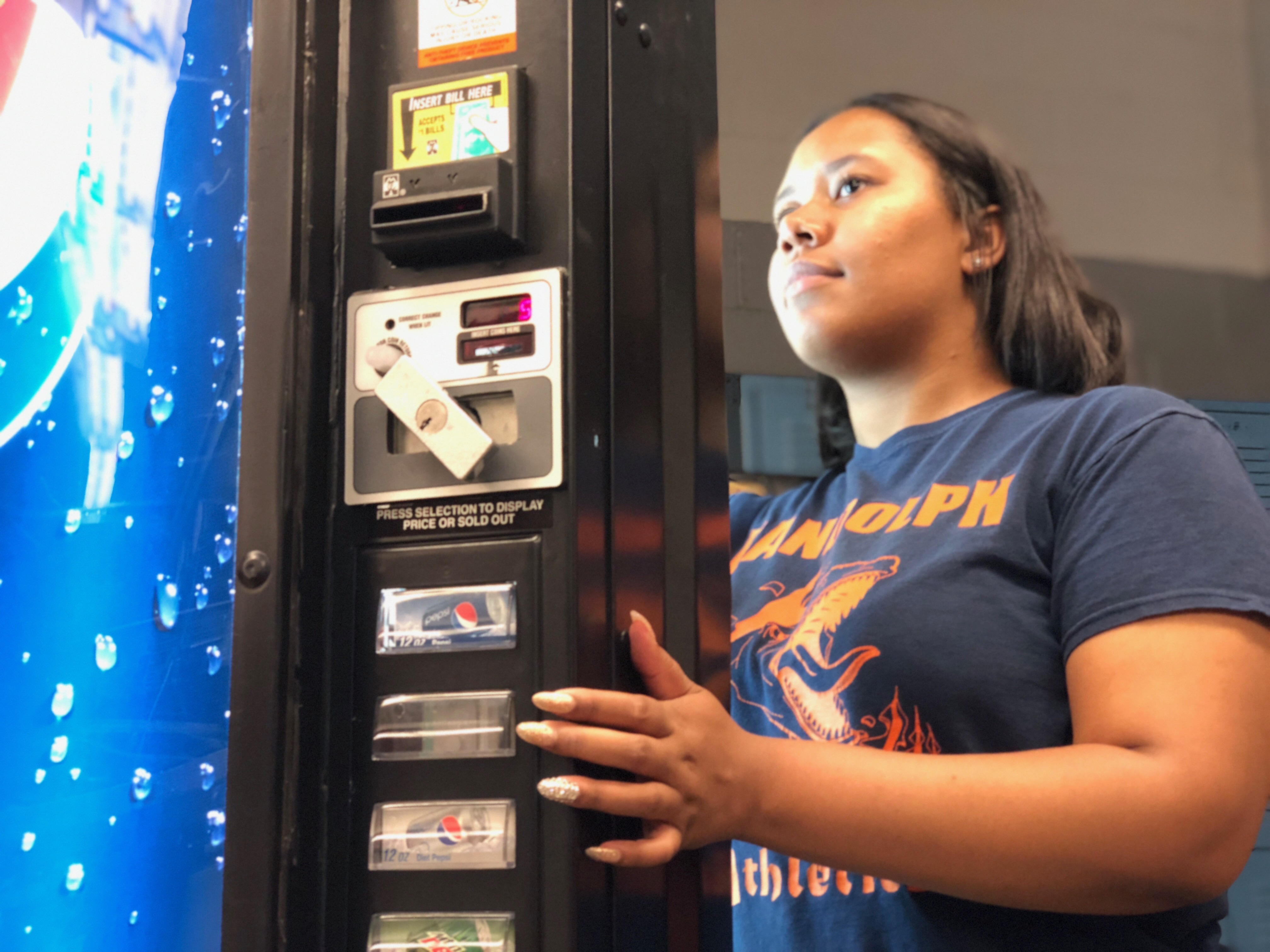 Vending students working on a soda machine. 