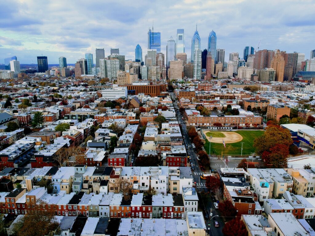 An aerial view of Center City Philadelphia with a neighborhood of rowhomes and baseball field in the foreground