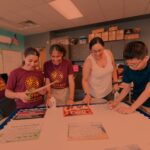 Science teacher leading 3 middle school students through a group activity