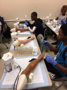 Biotech students learning to draw blood at Drexel simulation lab