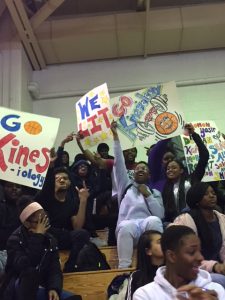 Kinesiology students holding posters cheering on their team