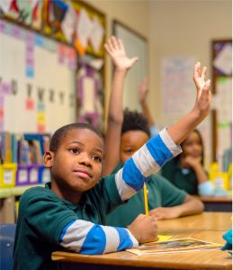 Young child raising hand in school