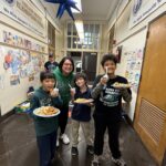 Students with food, smiling in hallway