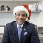Dr Watlington giving a Holiday Message wearing a santa hat
