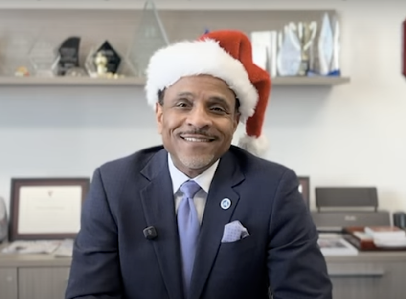Dr Watlington giving a Holiday Message wearing a santa hat