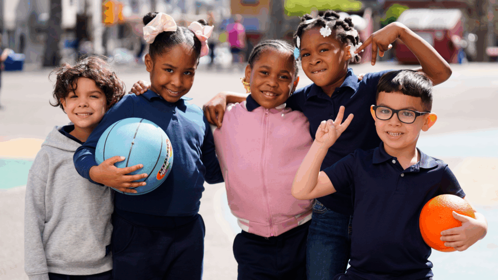five young students in playground with colorful balls, smiling